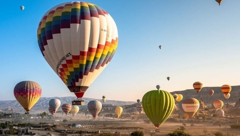 Colorful hot air balloons at sunrise flying over fairy chimneys and valleys of Cappadocia Turkey excursion from Istanbul
