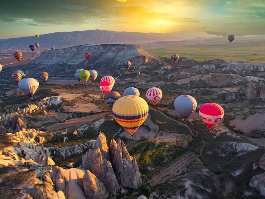 Vol au-dessus de la Cappadoce à 800 mètres d'altitude : des dizaines de montgolfières colorées flottant au lever du soleil au-dessus des formations rocheuses de tuf blanc et beige, des vallées arides et des habitations troglodytes. Vols réglementés par l'autorité aérienne turque, capacité de 24 à 32 passagers par montgolfière.