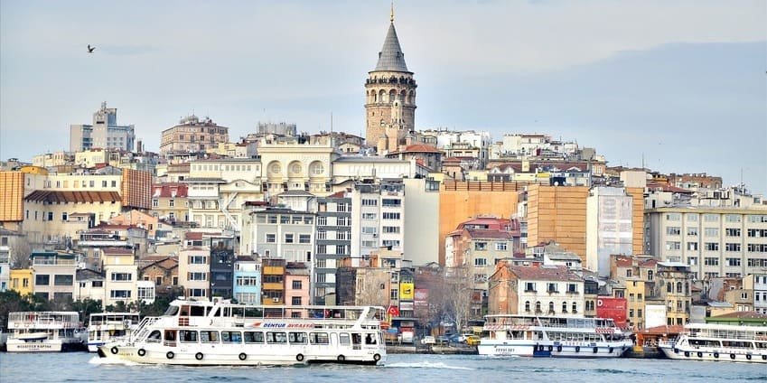 Je me trouve face à la tour de Galata qui domine Karaköy, avec des bateaux filant à toute allure sur la Corne d'Or au premier plan. Érigée en 1348, elle culmine à près de 67 mètres et sert de repère urbain.