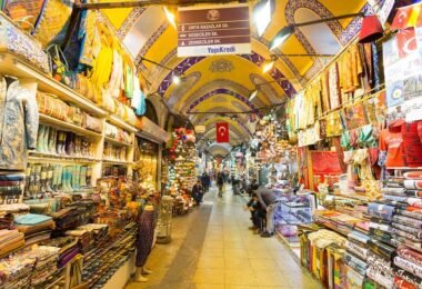 I am facing the stalls of the Grand Bazaar of Istanbul, a covered market founded in 1461, bringing together 4,000 shops over 30,000 m², a symbol of Ottoman commerce and heritage.