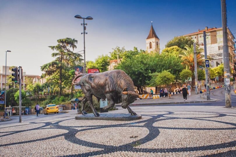 The famous bronze Bull statue (Boğa Heykeli) at the Altıyol intersection, a key meeting point in the heart of the Kadıköy district on the Asian side of Istanbul.