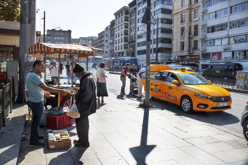 Tram rouge passant dans une rue animée du quartier de Sirkeci à Istanbul, entouré de bâtiments et de piétons.